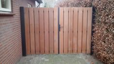 a wooden gate in front of a brick house