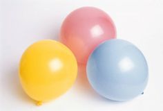 three balloons sitting next to each other on a white surface