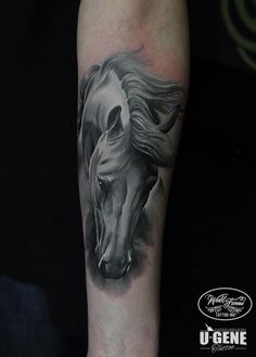 a black and white horse tattoo on the arm