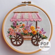 an embroidery pattern with flowers and a cart on the front is featured in this image