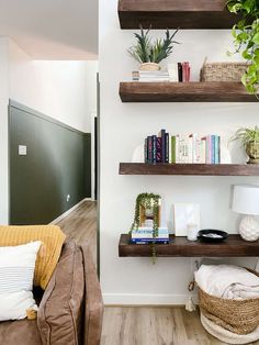 a living room filled with furniture and bookshelves on top of wooden shelves next to a wall