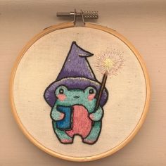 an embroidery project with a gnome holding a sparkler in it's right hand