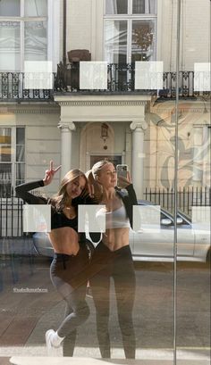 two women taking a selfie in front of a building with their arms around each other