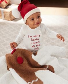 a baby wearing a santa hat on top of a bed