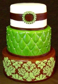 three tiered cake with green, brown and white designs on it's sides