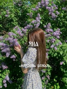 a woman standing in front of purple flowers with the words aha above her head