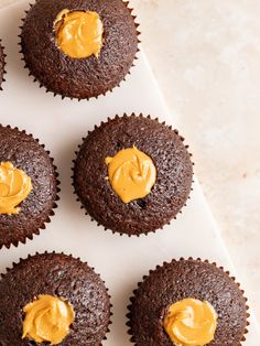 chocolate cupcakes with peanut butter frosting on white tray next to each other