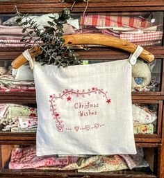 a christmas wish pillow hanging on a wooden rack