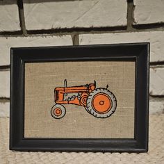 an embroidered picture frame with a tractor on it