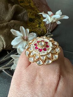 A statement ring with a beautiful and intricate design with Kundan stones. Size: Adjustable Elegant Festive Ring With Intricate Design, Traditional White Rings With Intricate Design, Traditional White Ring With Intricate Design, Round Ruby Ring With Stones For Wedding, Wedding Ruby Ring With Stones, Unique Jeweled Rings For Wedding, Jeweled Rings As Gifts, Unique Jeweled Anniversary Ring, Ruby Open Ring With Stone Setting For Wedding