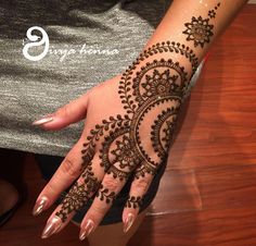 a woman's hand with henna tattoos on her left arm and the top half of