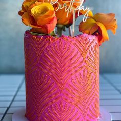 there is a pink vase with orange roses in it on the table and happy birthday