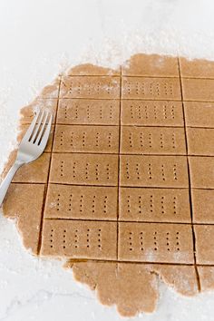 a fork is laying on top of some brown crackers that have holes in them