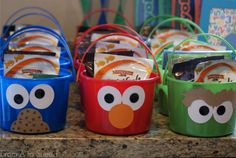 four buckets with different designs and faces on them sitting on a counter top next to each other