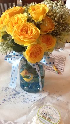 a vase filled with yellow roses and baby's breath on top of a table