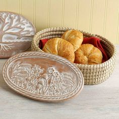 two baskets filled with croissants sitting on top of a table