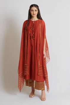 Rust long kurta with front tassel tie-ups. Paired with asymmetric hem cape with gold kanchi tissue scallop applique and pant.
Component: 3
Pattern: Plain
Neckline: Round
Sleeve Type: Slit
Fabric: Kora Chanderi, Organza, Cotton
Color: Orange
Other Details: 
Tissue broad border hem pant
Scalloped hem cape
Front tassel tie-up kurta
Occasion: Mehendi and Haldi - Aza Fashions Plazo Dress, Cape For Women, Long Kurta, Cape Style, Designer Dresses Casual, How To Hem Pants, Kurta Set, Scalloped Hem, Dresses Casual