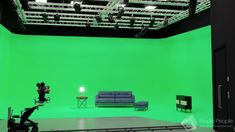 a green screen studio with couches and chairs in front of the camera set up