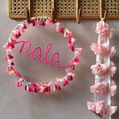 a pink flower lei with the word alla written in cursive letters on it