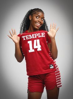 a woman in red shirt and shorts holding her hands up