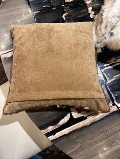 a brown pillow sitting on top of a wooden floor