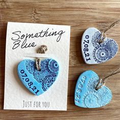 two handmade heart shaped magnets are sitting on a table next to each other