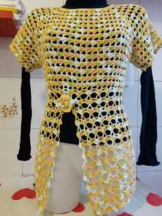 a crocheted top is displayed on a mannequin's head stand