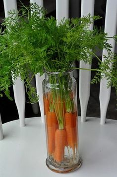 carrots and parsley in a glass vase on a white tableclothed chair