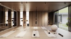 an empty room with yoga mats on the floor and exercise balls in front of glass doors