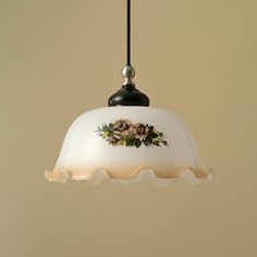 a white light hanging from a ceiling with flowers painted on the glass and metal parts