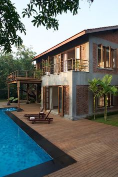 a house with a swimming pool in front of it and a deck on the other side