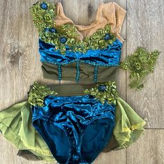 two piece swimsuit with green, blue and yellow trims on wood flooring