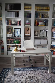 a white desk sitting on top of a rug in front of a bookshelf