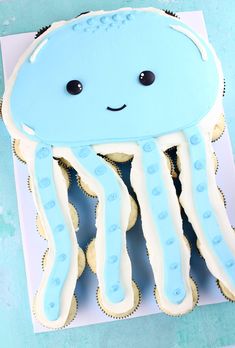 a blue cake with white icing and an octopus on it