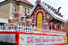 a float with people dressed as santa clause and gingerbread house on it's side