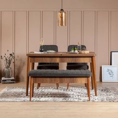 a wooden table with two chairs and a bench in front of it on top of a rug