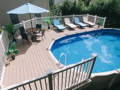 an above ground pool with decking and chairs