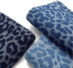 two pieces of blue and grey animal print fabric on white background with one piece folded up to the side