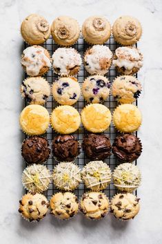 an overhead view of different types of cookies and muffins on a cooling rack