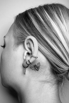 a woman's ear is adorned with tiny charms