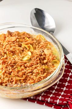 a glass bowl filled with food sitting on top of a red and white table cloth