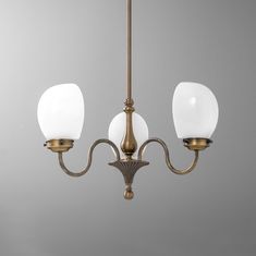 an antique brass chandelier with three white glass globes hanging from the ceiling