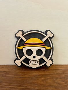 a wooden skull and crossbones with a yellow hat on it's head