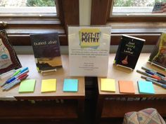 there are many books on the table with sticky notes in front of them, and one has a sign that says post - it poetry