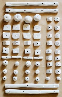 several white objects are laid out on a table top, including one large piece of wood and two smaller pieces of ceramic