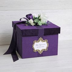 a purple gift box with white flowers on top