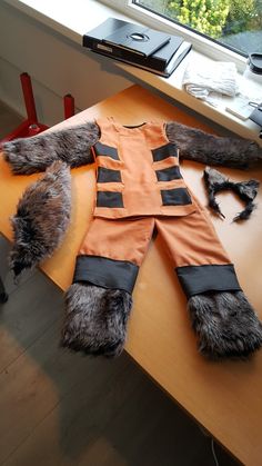 an orange and black costume sitting on top of a wooden table next to a window