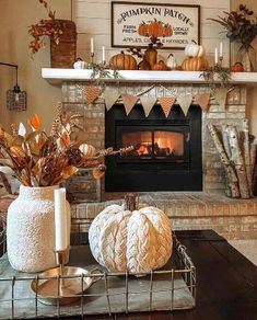 a fireplace decorated for fall with white pumpkins