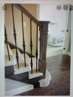 the stairs in this house are made of wood and wrought iron, with carpeted treads