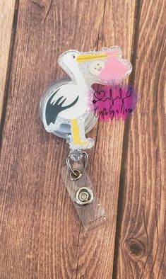 Stork with Baby Retractable Badge Reel. (Seen as pictured above). Handmade to order. Choose ONLY ONE The badge reel can be customized with your color choices. If you want a different color combo, simply put in the personalization section what colors you would like. Choose your Glitter from -> https://craftsbyanurse.weebly.com/glitter.html DETAILS: -This badge reel measures approximately 2 inches with the base 1/8-inch-thick acrylic with amazing quality and durability.  The badge reel is easy to clean (especially for healthcare workers!) -Hand glittered and sealed with resin/epoxy for added protection against wear and tear while also giving it a smooth finish. - 24" (belt clip) retractable badge reel -This is a handmade item and is made to order. No two items will be exactly the same. ** Al Customizable White Novelty Craft Supplies, Customizable White Craft Supplies For Hobby, Customizable White Badge Reel For Gift, Customizable White Badge Reel For Crafting, Novelty Personalized White Badge Reel, White Personalized Novelty Badge Holder, Customizable White Badge Holders For Personal Use, Customizable White Lanyards, Customizable Adjustable White Lanyards